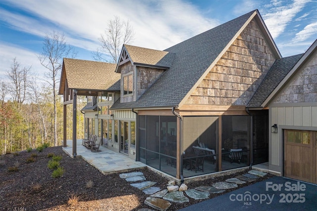 back of property with a patio area and a sunroom