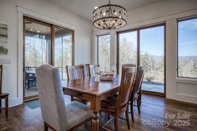 dining area featuring dark wood-type flooring and a chandelier