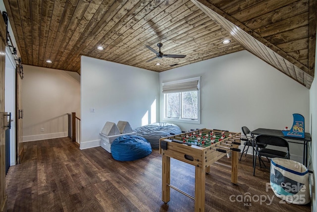 rec room with dark wood-type flooring, ceiling fan, a barn door, and wooden ceiling