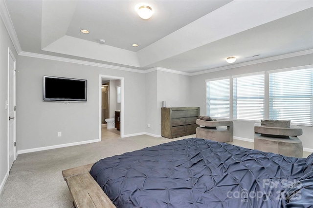 carpeted bedroom featuring crown molding, ensuite bath, and a raised ceiling