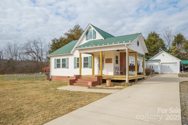 view of front of property featuring a garage, an outdoor structure, a front lawn, and covered porch