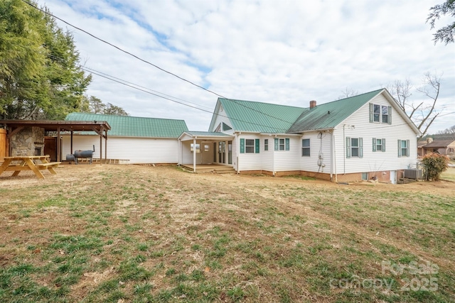 back of property featuring central AC and a lawn