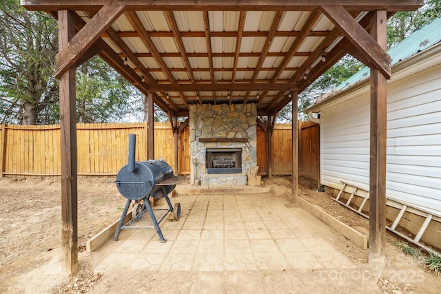 view of patio featuring a grill and an outdoor stone fireplace