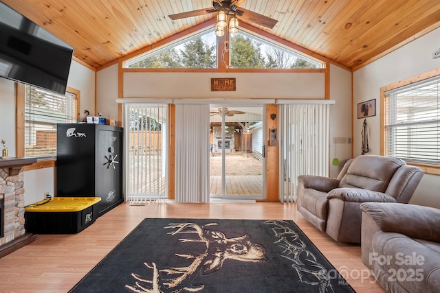 living room featuring wood ceiling, plenty of natural light, and a stone fireplace