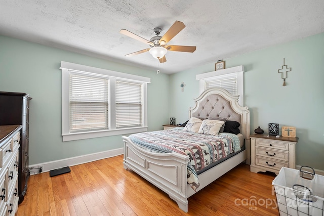 bedroom with ceiling fan, a textured ceiling, and light wood-type flooring