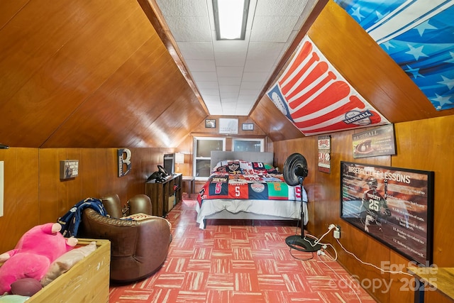 bedroom with lofted ceiling and wooden walls