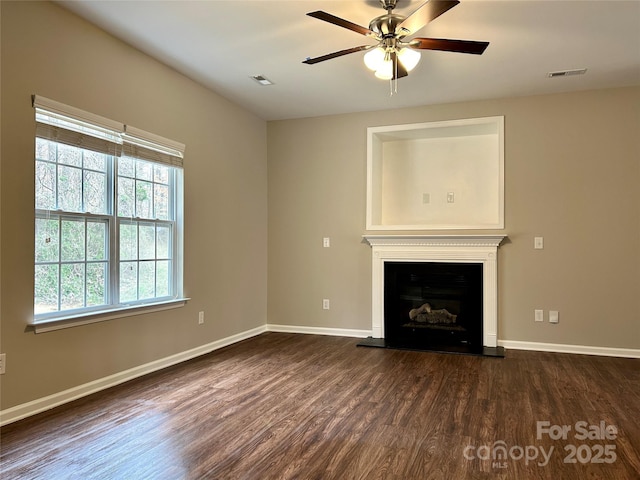 unfurnished living room with ceiling fan, visible vents, baseboards, and dark wood-style floors