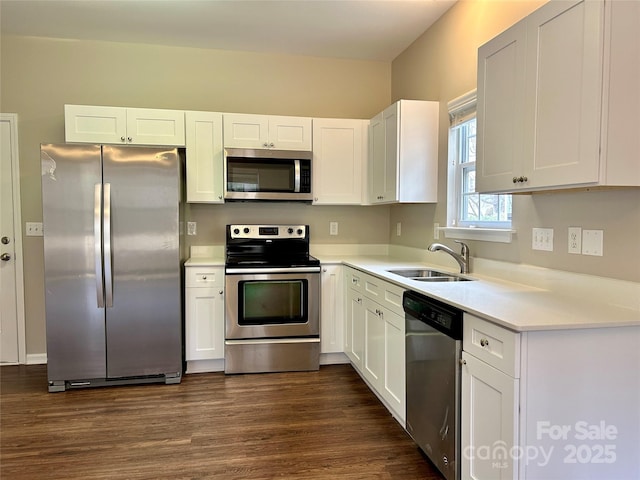 kitchen with a sink, dark wood-type flooring, appliances with stainless steel finishes, and white cabinetry