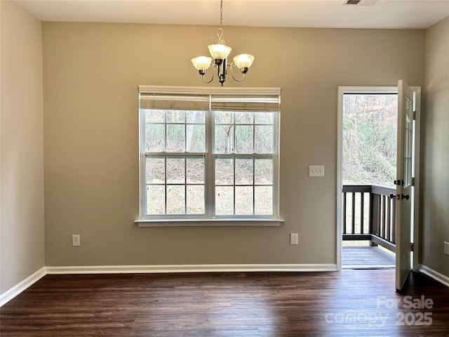 foyer entrance featuring dark wood finished floors, baseboards, visible vents, and a chandelier