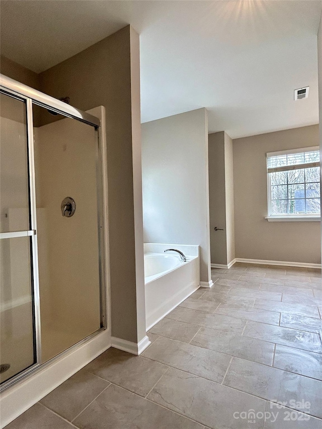 full bath featuring visible vents, a stall shower, baseboards, and a garden tub