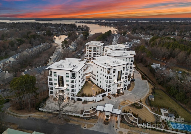 aerial view at dusk featuring a water view