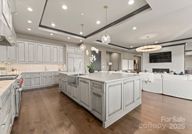 19329 Watermark Dr Unit 551/552, Cornelius, NC 28031 - kitchen featuring sink, stainless steel stove, hanging light fixtures, a spacious island, and a tray ceiling