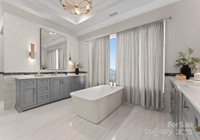19329 Watermark Dr Unit 551/552, Cornelius, NC 28031 - bathroom with an inviting chandelier, vanity, a tray ceiling, and a bathing tub