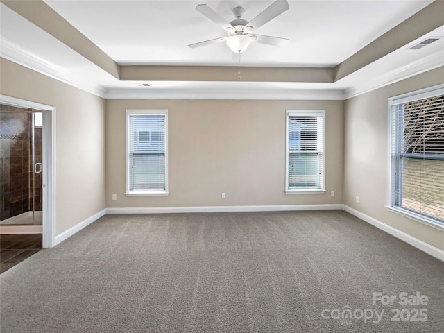 carpeted spare room with a tray ceiling, ornamental molding, and ceiling fan