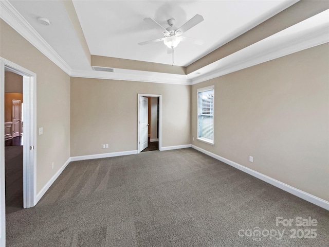 carpeted empty room with crown molding, a raised ceiling, and ceiling fan