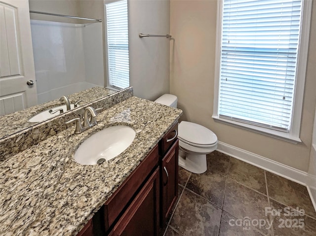 bathroom with walk in shower, vanity, and toilet