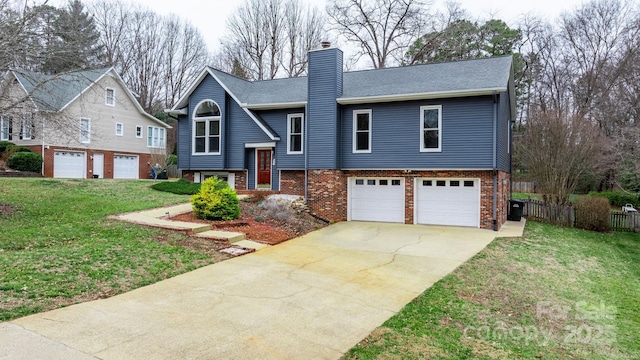 raised ranch featuring a garage and a front yard