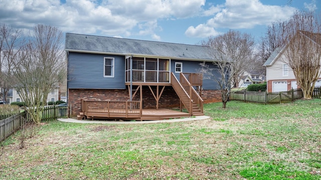 rear view of house with a sunroom, a deck, and a lawn