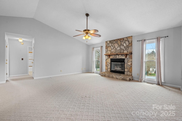 unfurnished living room featuring lofted ceiling, light colored carpet, a textured ceiling, ceiling fan, and a fireplace