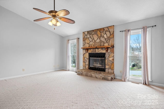 unfurnished living room with ceiling fan, a wealth of natural light, a fireplace, and a textured ceiling