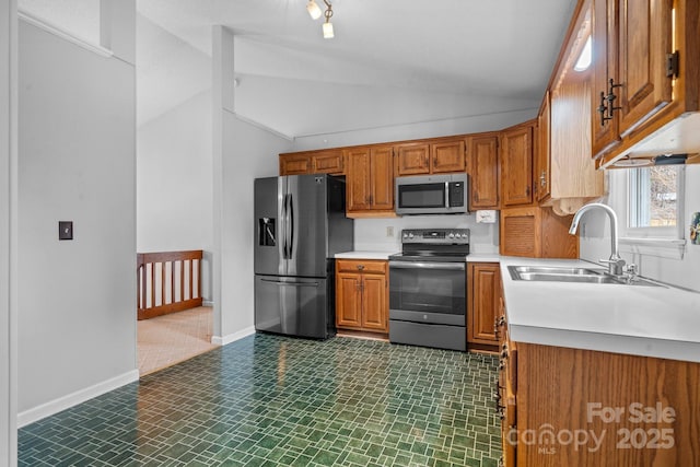 kitchen with stainless steel appliances, vaulted ceiling, and sink