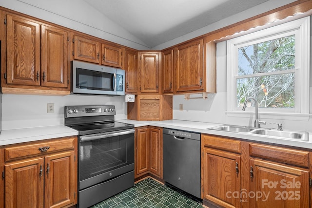 kitchen with lofted ceiling, stainless steel appliances, and sink