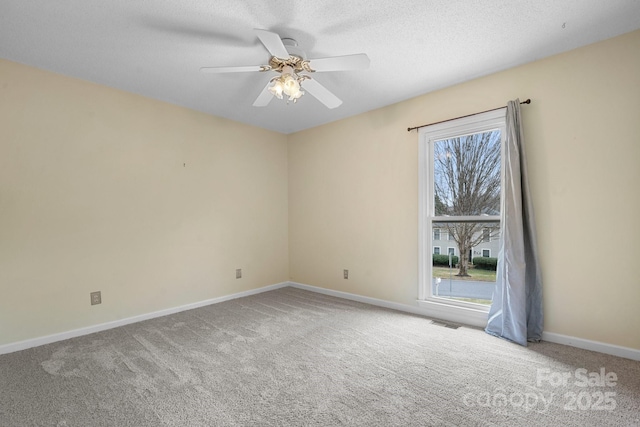 empty room featuring a textured ceiling, carpet floors, and ceiling fan