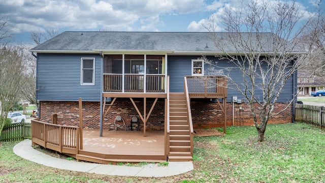 back of house featuring a wooden deck, a sunroom, and a yard