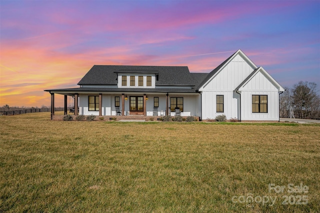 modern farmhouse style home with a porch and a lawn