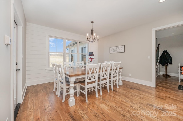 dining space featuring an inviting chandelier and light hardwood / wood-style flooring