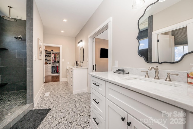 bathroom featuring vanity, tile patterned flooring, and tiled shower