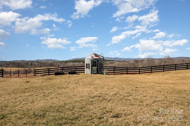 view of yard featuring a rural view and a shed