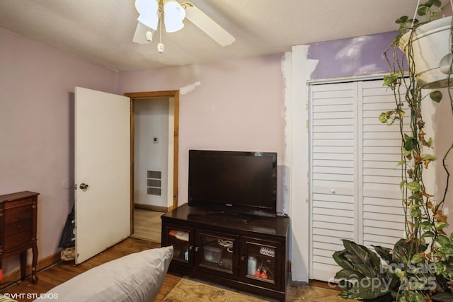 living room with wood-type flooring and ceiling fan