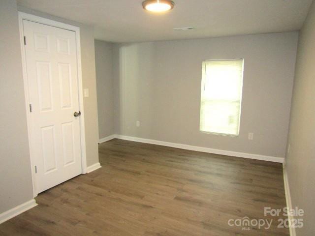 empty room with dark wood-type flooring