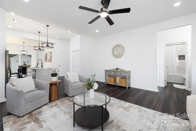 living room with ceiling fan, sink, and dark hardwood / wood-style flooring