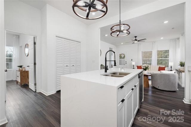 kitchen featuring plenty of natural light, a kitchen island with sink, sink, and white cabinets