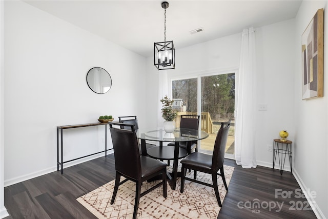 dining area featuring dark hardwood / wood-style floors and a notable chandelier