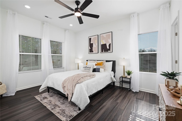 bedroom featuring multiple windows, dark wood-type flooring, and ceiling fan