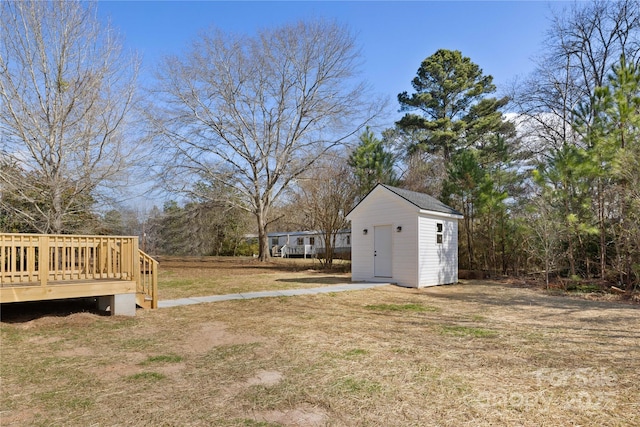 view of yard featuring a storage unit and a deck