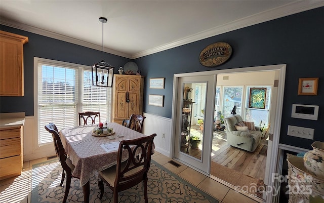 660 Scoggins Rd, Rutherfordton, NC 28139 - dining area with wainscoting, light tile patterned floors, crown molding, and a chandelier