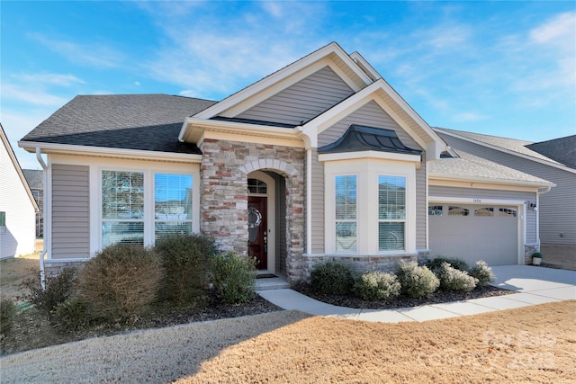 view of front of house featuring a garage, stone siding, roof with shingles, and driveway