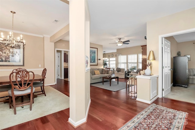 dining space with ceiling fan with notable chandelier and dark hardwood / wood-style flooring