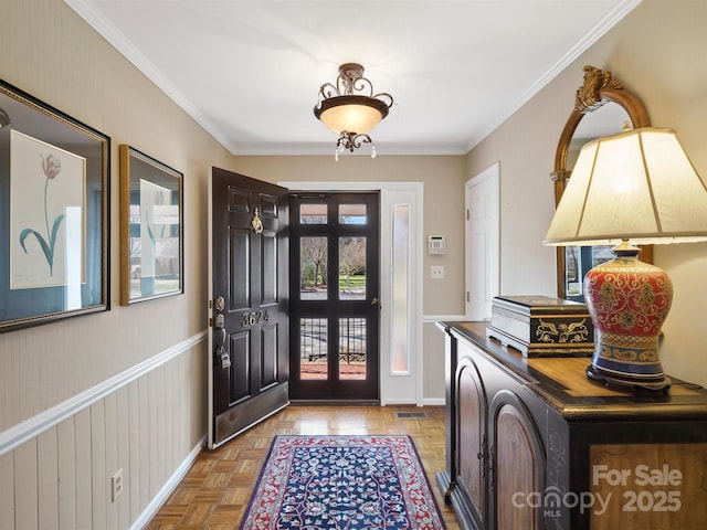 entrance foyer featuring ornamental molding and light parquet flooring