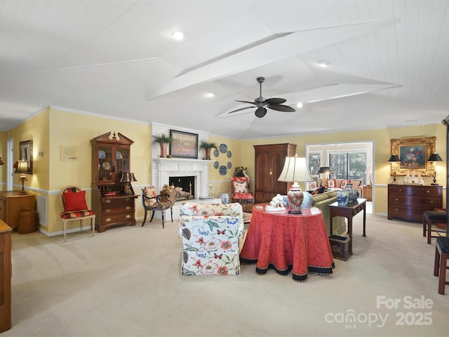 carpeted living room featuring crown molding, ceiling fan, vaulted ceiling, and a brick fireplace