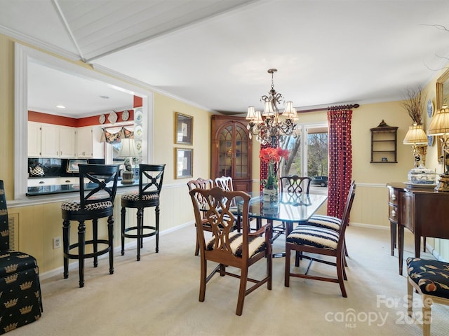 carpeted dining room with crown molding and a chandelier