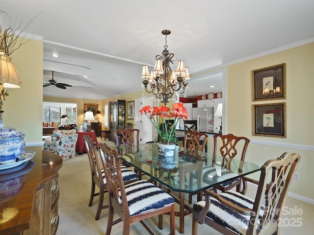 carpeted dining room with ornamental molding and ceiling fan with notable chandelier