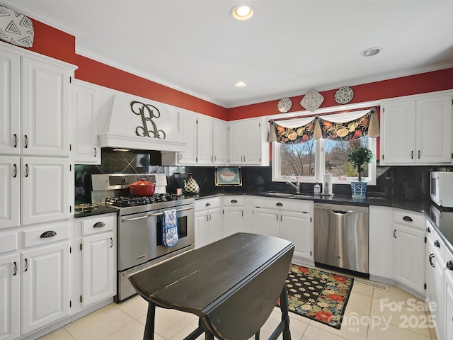 kitchen with stainless steel appliances, white cabinets, and backsplash