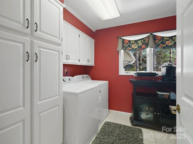 laundry area with cabinets, light tile patterned floors, and washer and dryer