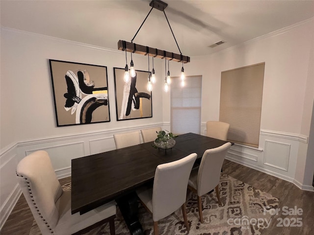 dining space featuring dark hardwood / wood-style flooring and crown molding