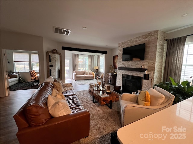 living room featuring plenty of natural light, a fireplace, and dark hardwood / wood-style flooring